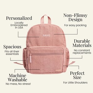 May include: A pink corduroy backpack with a zippered pocket and a name tag that says "NAME". The backpack is machine washable and has a spacious design.