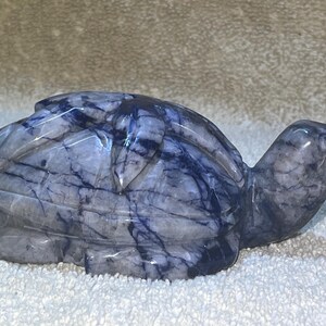 May include: A blue and white marble turtle sculpture. The turtle is carved in a realistic style and has a detailed shell.