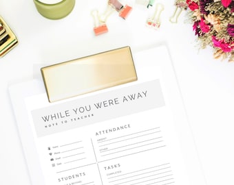 May include: A white notepad with the text "WHILE YOU WERE AWAY NOTE TO TEACHER" is held by a gold-colored clip. The notepad includes sections for attendance, tasks, and student notes. Other items include a green candle, paper clips, and dried flowers.