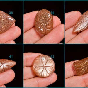 Peut inclure: Six cabochons de pierre de soleil avec des motifs floraux grav&eacute;s. Les pierres sont de diff&eacute;rentes nuances de brun et d'orange avec un effet chatoyant et iris&eacute;. Les cabochons sont num&eacute;rot&eacute;s de 38 &agrave; 43.