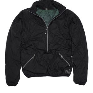 May include: A black quilted jacket with a zip fastening and a small logo patch that says "Be" on the bottom right side.