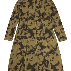 Puede incluir: Una larga chaqueta de pana marrón con un estampado abstracto negro y marrón.