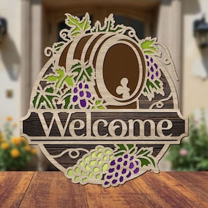 May include: Wooden welcome sign with a brown wine barrel, green grape vines, and purple grapes. The sign says "Welcome" in a rustic font.
