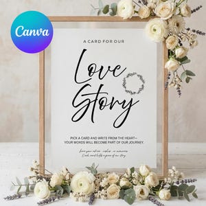 May include: A framed sign with the words "Love Story" in elegant script. The sign is surrounded by white flowers and greenery, with additional text at the bottom. The Canva logo is in the upper left corner.