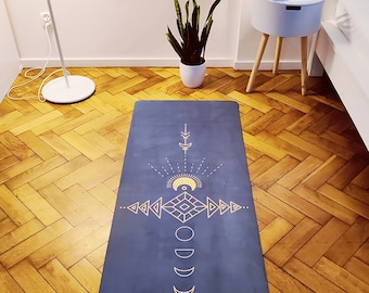 May include: A blue yoga mat with a gold geometric design featuring a sun, moon, and stars. The mat has the text "WILD ESSENCE" printed on the bottom right corner.
