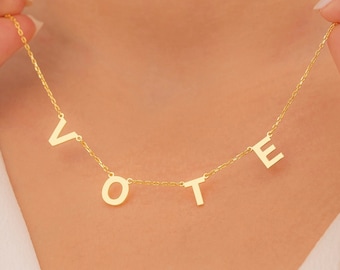 以下が含まれることがあります： VOTEと綴られた個別の文字でできた金のネックレス