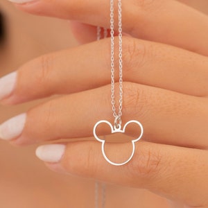 May include: A silver chain necklace with a silver pendant shaped like a Mickey Mouse head.