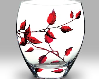 May include: A clear glass vase with a red floral design. The vase has a rounded body and a wide mouth.