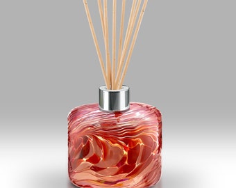 May include: A red glass diffuser bottle with a silver cap and wooden sticks. The bottle has a swirling, marbled pattern.