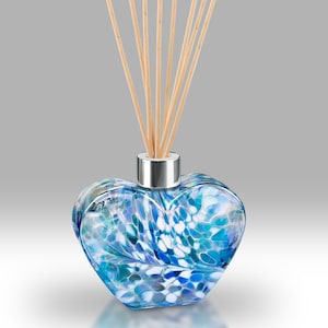 May include: A heart-shaped glass diffuser bottle with a blue and white swirl pattern and wooden sticks.