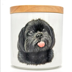 May include: A white ceramic jar with a wooden lid, featuring a hand-painted image of a black Shih Tzu dog with its tongue sticking out.