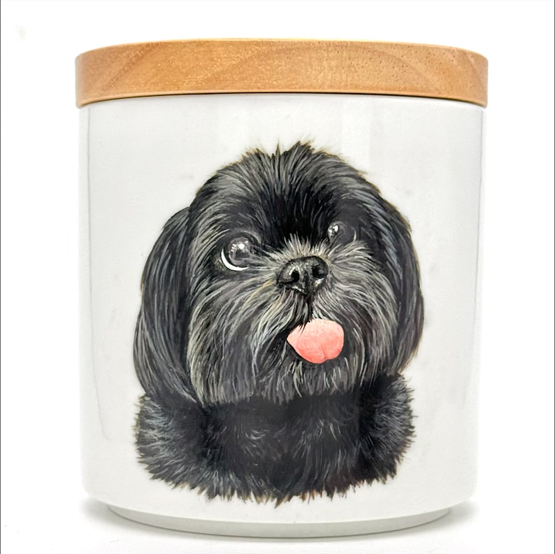 May include: A white ceramic jar with a wooden lid, featuring a hand-painted image of a black Shih Tzu dog with its tongue sticking out.