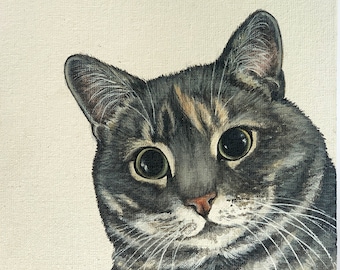 Op de afbeelding: Een close-up schilderij van een kattenkop. De kat heeft grijs, zwart en bruin haar met groene ogen. De kat kijkt recht naar de kijker.