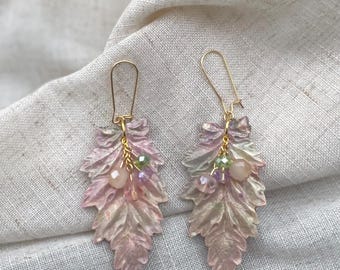 May include: A pair of pink and green leaf-shaped earrings with gold accents and small pink, green, and purple beads.