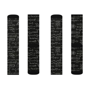 K&ouml;nnte beinhalten: Schwarze Socken mit wei&szlig;en mathematischen Gleichungen und Symbolen. Die Socken zeigen ein sich wiederholendes Muster aus komplexen Formeln, Integralen und wissenschaftlicher Notation. Ideal f&uuml;r Wissenschaftsinteressierte.