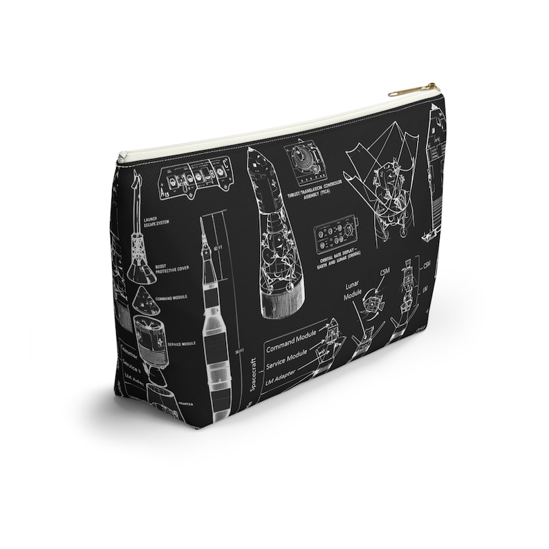 May include: Black cosmetic bag featuring a white diagram of a rocket and spacecraft components. The bag has a gold zip and a white interior. The diagram includes labels such as "Command Module" and "Lunar Module".