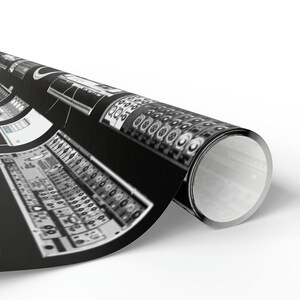 May include: A black and white image of a rolled up poster featuring a close-up of a vintage audio mixing board with knobs and dials.
