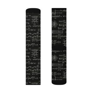 K&ouml;nnte beinhalten: Schwarze Socken mit einem wei&szlig;en mathematischen Formeldesign. Die Socken zeigen verschiedene Gleichungen und Symbole und schaffen eine einzigartige und lehrreiche &Auml;sthetik. Ein tolles Geschenk f&uuml;r Wissenschaftsbegeisterte.