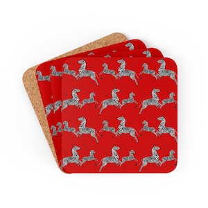 May include: Set of four red cork coasters with a repeating pattern of black and white zebras running.