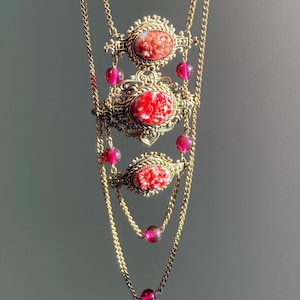 Vintage Czechoslovakia/Bohemia multi strand necklace; relief inserts floral pattern Peking pressed glass featuring, cranberry glass beads