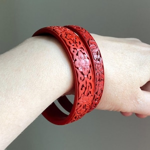 A beautiful pair of vintage Chinese export cinnabar bracelets with floral designs