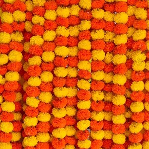 K&ouml;nnte beinhalten: Eine dichte Wand aus Ringelblumen-Girlanden, die in vertikalen Str&auml;ngen angeordnet sind. Die Bl&uuml;ten haben leuchtende Gelb- und tiefe Oranget&ouml;ne und bilden ein sich wiederholendes, strukturiertes Muster aus runden, ger&uuml;schten Bl&uuml;ten.