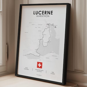 May include: Framed Lucerne Marathon map print in black and white. The print includes the marathon route, the Swiss flag, and text that reads "LUCERNE MARATHON". The print also includes the date, distance of 42.195 km, and time.