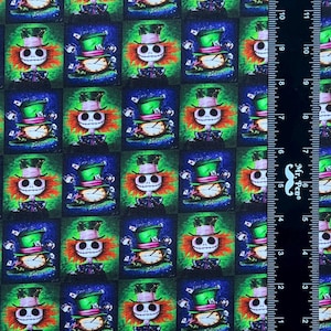 May include: A repeating pattern fabric featuring a green, blue, and black background with a cartoon character wearing a green hat and a red and white striped shirt. The character has a skull-like face with a wide grin. The fabric is perfect for crafting projects.