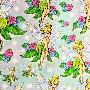 May include: A repeating pattern of Tinkerbell fairies with iridescent wings sitting on green leaves with pink, blue, and white flowers on a light blue background.