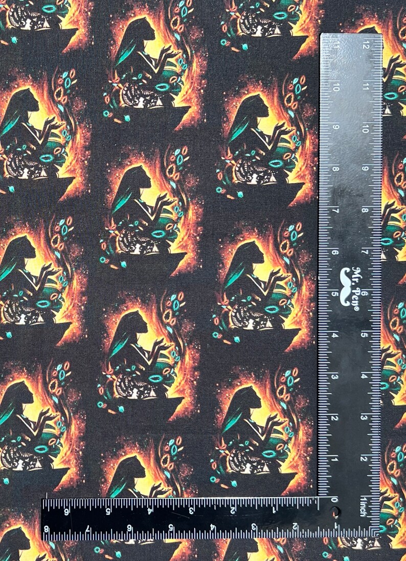 May include: A black fabric with a repeating pattern of a woman's silhouette in a teal dress, holding a glowing orb. The background is a dark, starry sky with orange and yellow accents.