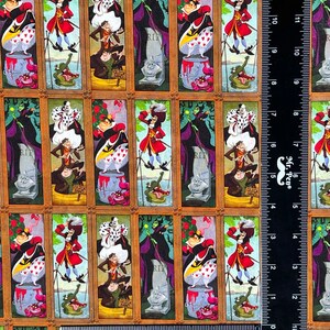 May include: Fabric featuring framed portraits of Disney villains and characters. The portraits include the Queen of Hearts, Captain Hook, and the Evil Queen. The background is a tan color with a repeating pattern of the framed portraits.