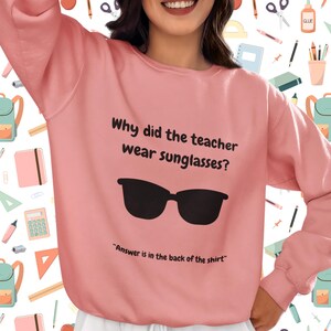 Funny Teacher Sweatshirt, "Bright Students" Graphic Pullover, Unisex Cozy Apparel with Quote: Why did the teacher wear sunglasses? a black sunglasses is designed in the apparel. *Answer is in the back of the shirt - Because her students sere so bright! Female model wearing dusty rose color sweatshirt.