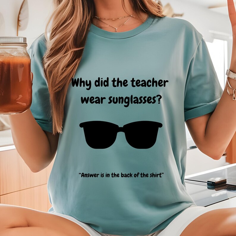 Funny Teacher T-Shirt, "Bright Students" Graphic Tee, Unisex Shirt with Quote: Why did the teacher wear sunglasses? a black sunglasses is designed in the apparel. *Answer is in the back of the shirt - Because her students sere so bright! Female model wearing seafoam color t-shirt.
