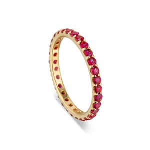 Könnte beinhalten: Ein Goldring mit einer Reihe kleiner, roter Rubin-Steine, die um die gesamte Band gefasst sind.