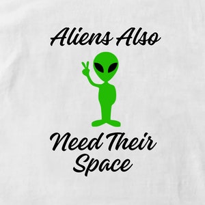 May include: A white t-shirt with a green alien graphic and the text "Aliens Also Need Their Space" in black.