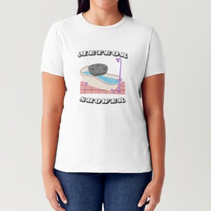 May include: White t-shirt with a graphic of a bathtub with a meteor in it. The text "METEOR SHOWER" is printed below the graphic.