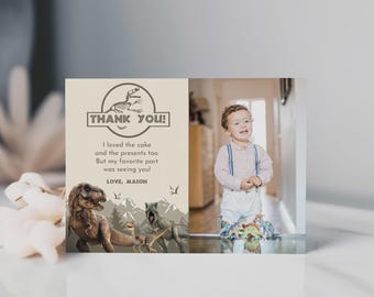 May include: A rectangular thank you card featuring a dinosaur theme with a skeleton logo, the text 'THANK YOU! I loved the cake and the presents too. But my favorite part was seeing you! LOVE, MASON', illustrations of three dinosaurs, and a photo of a child.
