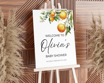 May include: A white welcome sign with a watercolour illustration of orange blossoms and fruit. The text reads "Welcome to Olivia's Baby Shower, Saturday, February 15th, 20XX".