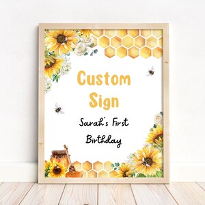 May include: A printable sign with a honeycomb pattern, sunflowers, and bees. The text reads "Custom Sign" and "Sarah's First Birthday".