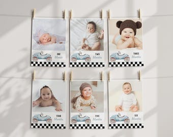 May include: Six rectangular milestone cards featuring photographs of a baby at different ages. Each card displays a light blue vintage race car illustration, a black and white checkered border, and text ranging from One Month to Six Months.