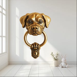 May include: A gold-toned door knocker shaped like a dog's head with a ring for knocking. The dog's head is detailed with realistic features, including a black nose and brown eyes.
