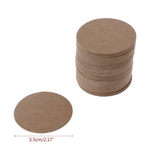 May include: A stack of 50 round, brown kraft paper gift tags with a hole punched in the top. Each tag measures 5.5 cm in diameter.