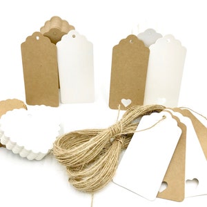 May include: A set of brown and white gift tags with scalloped edges and a heart-shaped hole. The tags are arranged on a white surface with a spool of twine.