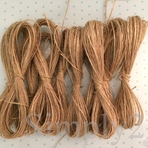 May include: Eight spools of natural brown twine, each tied in a knot. The twine is made of natural fibres and is perfect for crafting, wrapping, and decorating.