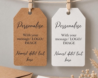May include: Two rectangular tags, one brown kraft paper and one white, hang from a string by wooden clips. Each tag features the black printed text: Personalise, With your message/ LOGO/ IMAGE, and Names/ date/ text here, with a hole at the top.
