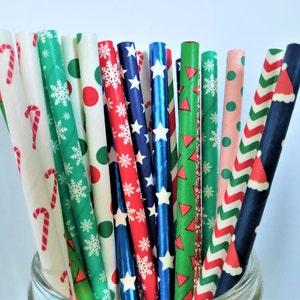 May include: A bunch of colourful paper straws with various Christmas-themed patterns, including snowflakes, candy canes, and Santa hats.