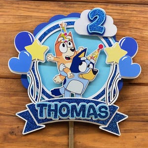 Personalised Children's Birthday Cake Topper Blue Cartoon Theme Inspired Design. Cake Topper comes fitted with Acrylic Stick.