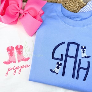 Puede incluir: Dos camisetas infantiles. Una es blanca con botas de vaquero rosas y el nombre "pippa" en cursiva. La otra es azul claro con un monograma y detalles de botas de vaquero. Un gran lazo rosa está en el fondo.
