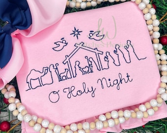 May include: Pink baby onesie with a blue embroidered nativity scene and the text "O Holy Night".