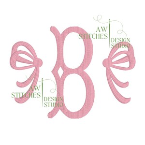 May include: Pink embroidered letter B with two pink bows on either side. The letter is in a script font. The bows are stylized and have a loop at the top.